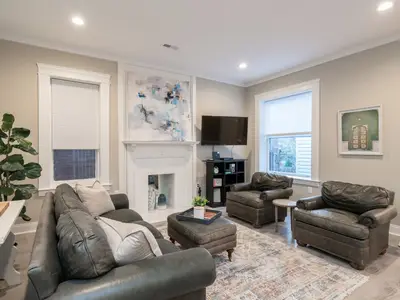 Upper-floor living room with white fireplace mantel and leather armchairs at 4632 McPherson (Historic Haven)