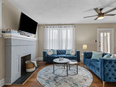 Living room with painted brick fireplace, mounted TV, and board games on the mantel