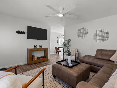Living room seating area with wall-mounted TV, console table, and patterned area rug